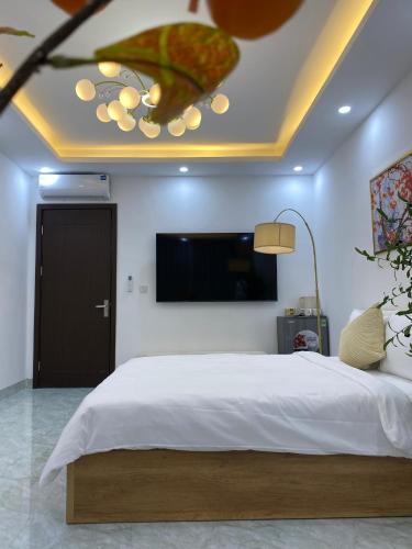 a bedroom with a large bed and a flat screen tv at The Grand Diamond C Tuong Mai in Hanoi
