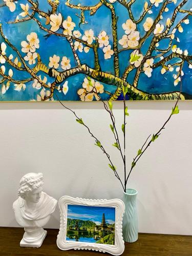 a picture of a tree with white flowers in a vase at The Grand Diamond C Tuong Mai in Hanoi