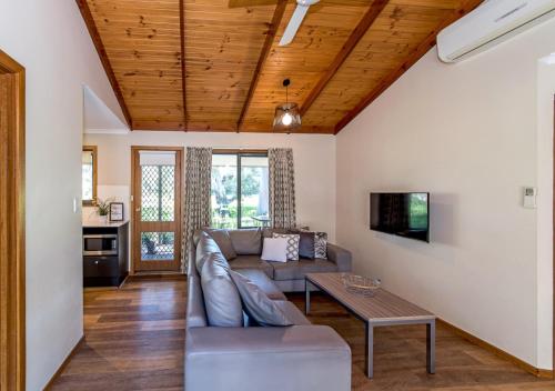a living room with a couch and a table at Marion Holiday Park in Adelaide