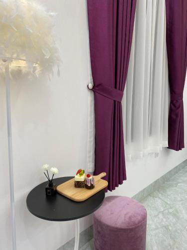 a table with a cake and a purple stool at The Grand Diamond C Tuong Mai in Hanoi
