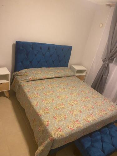 1 cama con cabecero azul en un dormitorio en paseo San Carlos, en Coquimbo