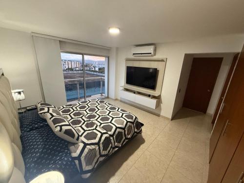 a bedroom with a bed and a flat screen tv at Apartamento de Lujo in Floridablanca