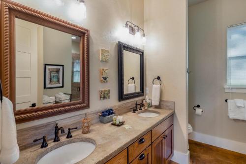 a bathroom with two sinks and a large mirror at Driftwood Casitas - Birdsong Casita in Wimberley