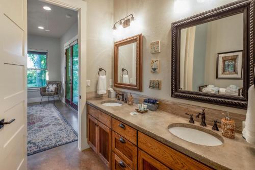 a bathroom with two sinks and a large mirror at Driftwood Casitas - Birdsong Casita in Wimberley
