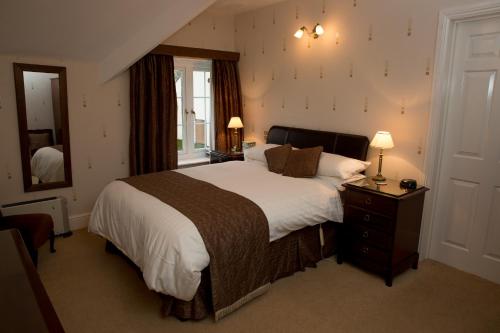 a bedroom with a large bed and a mirror at Weir Mill Farm in Cullompton