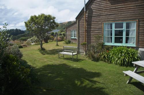 a bench sitting in a yard next to a house at Hilltop guest room, Escape the city! in Pukehiki