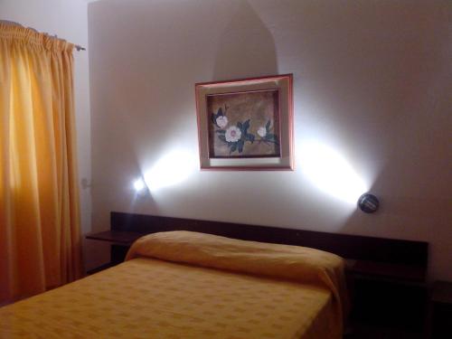 a bedroom with a bed and a painting on the wall at Alojartur in San Rafael