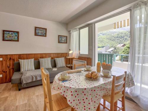 un salon avec une table et un canapé dans l'établissement Appartement cosy pour 4 à Gourette, balcon sud-ouest et services optionnels - FR-1-400-134, à Eaux-Bonnes