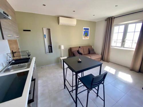 une cuisine et un salon avec une table et un canapé dans l'établissement Appartement Central Climatisé au Lavandou - Proche Plage - FR-1-816-6, au Lavandou