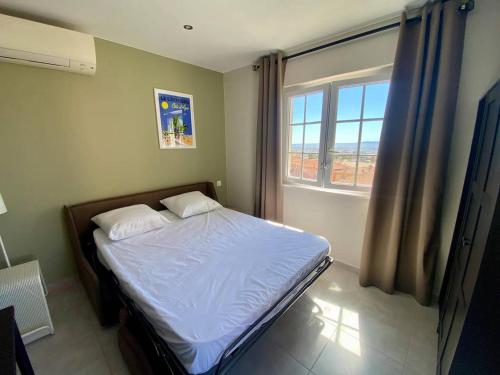 une chambre avec un lit avec des draps blancs et une fenêtre dans l'établissement Appartement Central Climatisé au Lavandou - Proche Plage - FR-1-816-6, au Lavandou