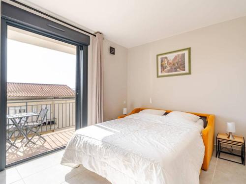 une chambre avec un lit et un balcon dans l'établissement Charmant studio rénové au cœur du Lavandou avec clim et terrasse - FR-1-816-7, au Lavandou