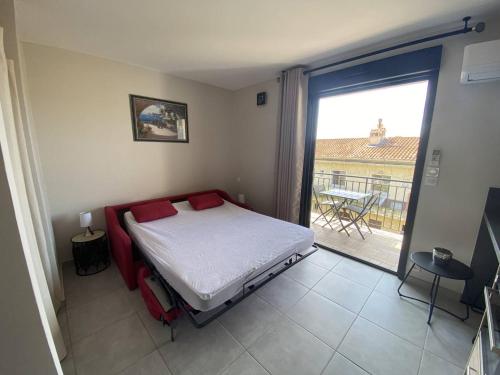 une chambre avec un lit et une vue sur un balcon dans l'établissement Studio rénové au cœur du Lavandou avec terrasse et climatisation - FR-1-816-10, au Lavandou