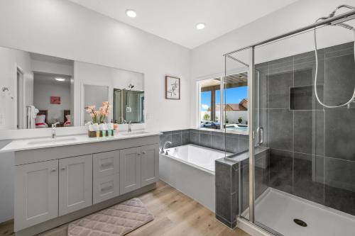 a bathroom with a shower and a tub and a sink at Spacious Backyard, Pool & Hot Tub, Gameroom by MariamsBnb in Desert Hot Springs
