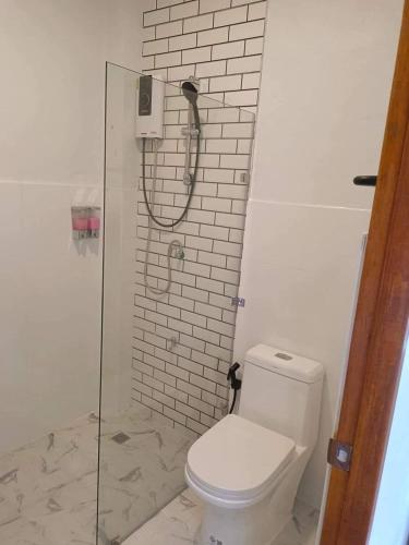 a white bathroom with a shower and a toilet at ไวท์เฮาส์ ภูชี้ฟ้า in Ban Tin Pet