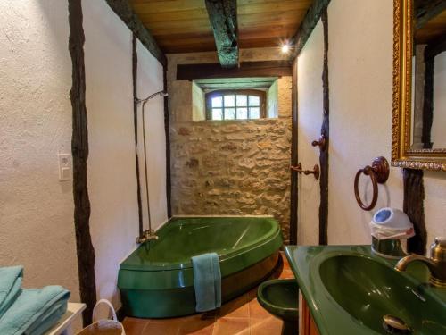a bathroom with a green tub and a sink at Maison campagnarde avec piscine et cheminée, Périgord Noir - FR-1-616-395 in Thenon