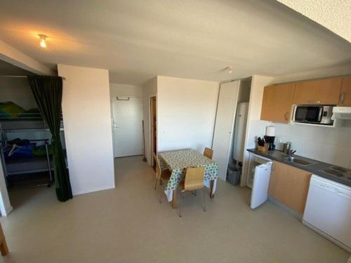 une petite cuisine avec une table et des chaises dans une pièce dans l'établissement Appartement 7 pers avec équipement complet à Arette - FR-1-602-118, à Arette