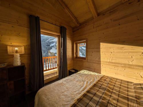 a bedroom with a bed and a window in a cabin at Chalet 4 chambres, confort moderne, Arêches-Beaufort - FR-1-342-331 in Beaufort