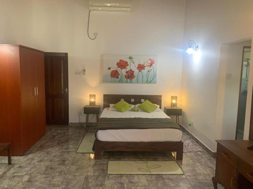 a bedroom with a bed and two tables and a painting on the wall at Supreme Serenity Villa in Talawatugoda