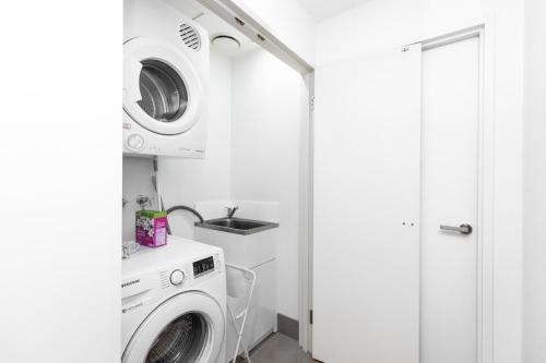 a white laundry room with a washer and dryer at Your Luxury Weekend Getaway in Wentworth Point in Sydney