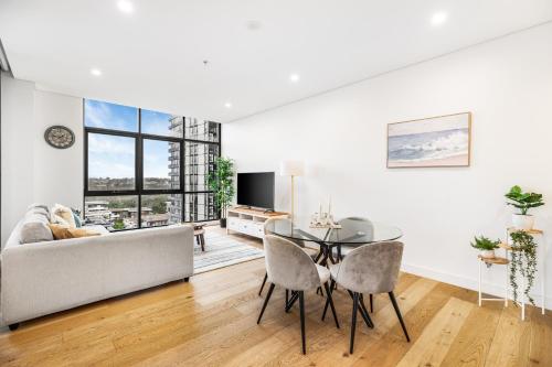 a living room with a table and a couch at Your Luxury Weekend Getaway in Wentworth Point in Sydney