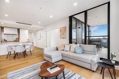 a living room with a couch and a table at Your Luxury Weekend Getaway in Wentworth Point in Sydney