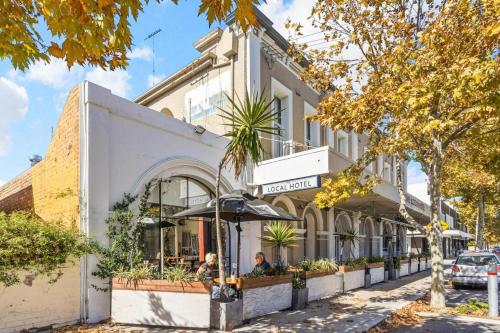 a building on a street with people sitting outside of it at Fremantle Townhouse u/5 in Fremantle