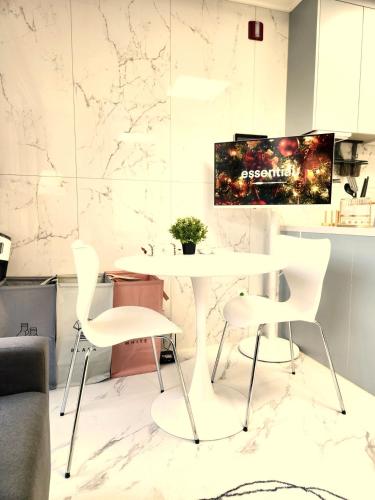 a dining room with a white table and chairs at Majestic Seoul Stay Central in Seoul