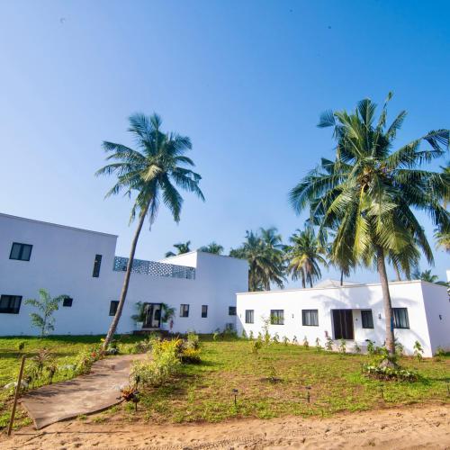 a white building with palm trees in front of it at Masque Lagos in Lagos