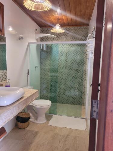 a bathroom with a shower and a toilet and a sink at Pousada Iyalodê in Marau