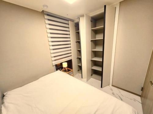 a small bedroom with a bed and a window at Majestic Seoul Stay Central in Seoul