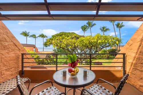 a table with a bowl of fruit on a balcony at Kuleana Club #510 - Ocean View -1 bedroom & 1 bathroom - 2nd Floor in Kahana