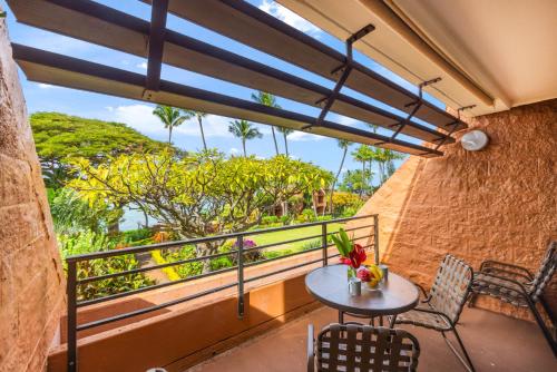 a balcony with a table and chairs and a window at Kuleana Club #510 - Ocean View -1 bedroom & 1 bathroom - 2nd Floor in Kahana
