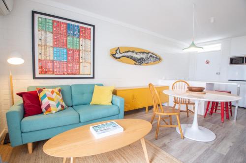 a living room with a blue couch and a table at City Living in Fremantle