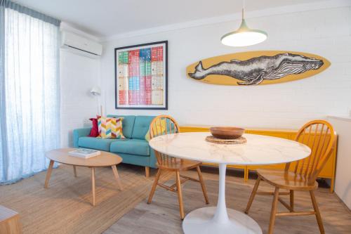 a living room with a table and a blue couch at City Living in Fremantle