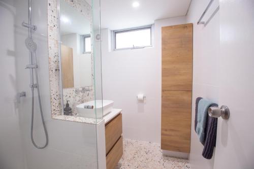a bathroom with a shower with a sink and a mirror at City Living in Fremantle