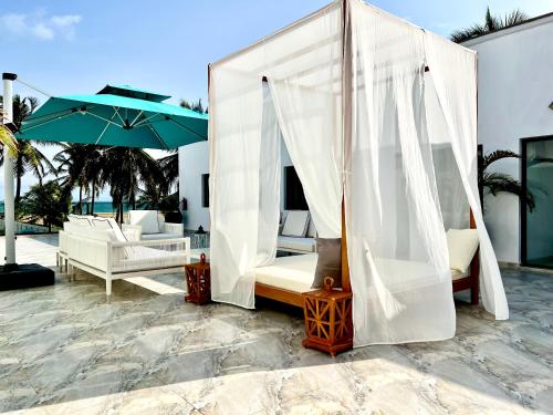 a canopy bed on a patio with an umbrella at Masque Lagos in Lagos