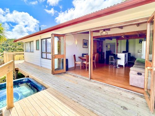 a house with a deck with a hot tub at Ngunguru Lodge in Ngunguru