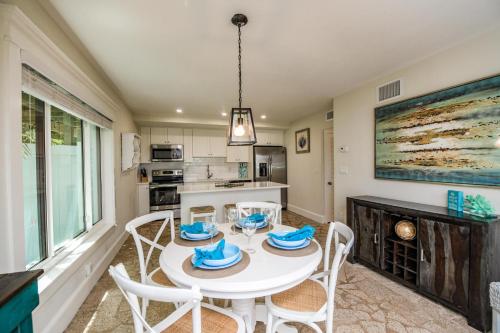 a kitchen and dining room with a white table and chairs at Bay Breezes at Bayside Bungalow in Anna Maria