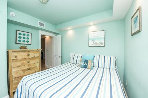 a bedroom with a bed with a striped bedspread at Bay Breezes at Bayside Bungalow in Anna Maria