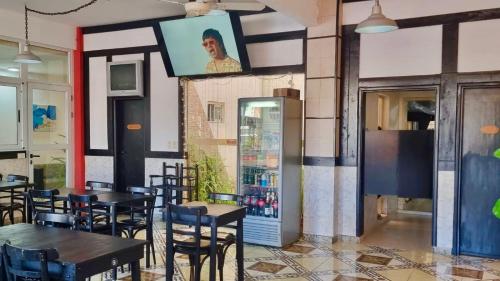 Un restaurante con mesas y sillas y un televisor en la pared. en NEW Hotel Playa, en Santa Teresita