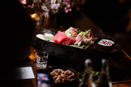 a table with a plate of food on a table at Hotel Indigo Brisbane City Centre by IHG in Brisbane