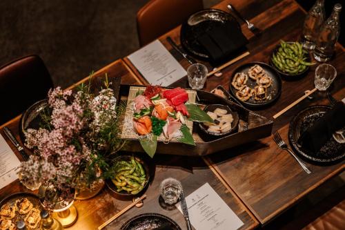 a wooden table with plates of food on it at Hotel Indigo Brisbane City Centre by IHG in Brisbane