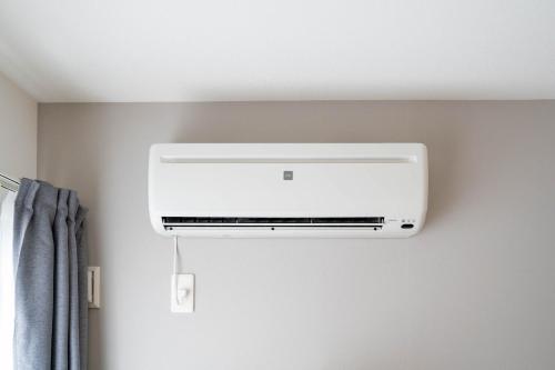 a white air conditioner hanging from a wall at Altiplano in Sapporo