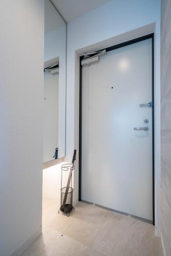 a large white door in a room with a tripod at Altiplano in Sapporo