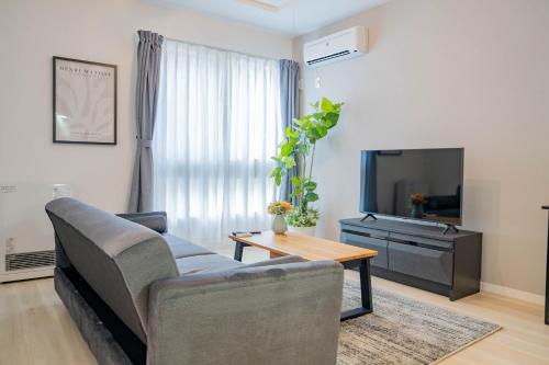 a living room with a couch and a tv at Altiplano in Sapporo