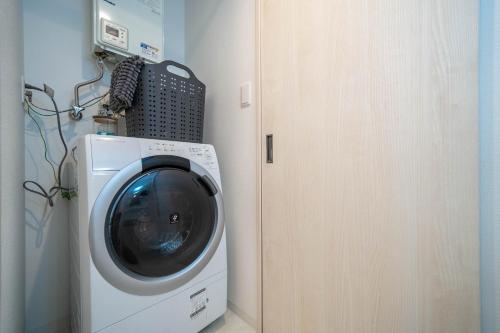 a washing machine in a room next to a door at Altiplano in Sapporo
