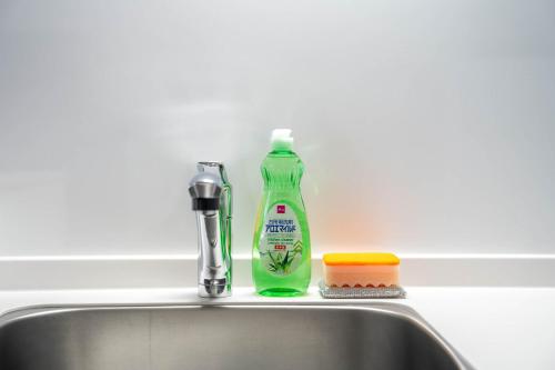 a green bottle of detergent sitting on top of a sink at Altiplano in Sapporo