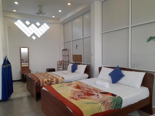 a bedroom with two beds and a window at Southceylon77 in Weligama