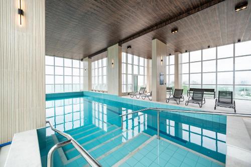 a large swimming pool with chairs and tables at Riviera Concept 2 dorm by Achei Camboriú in Itajaí