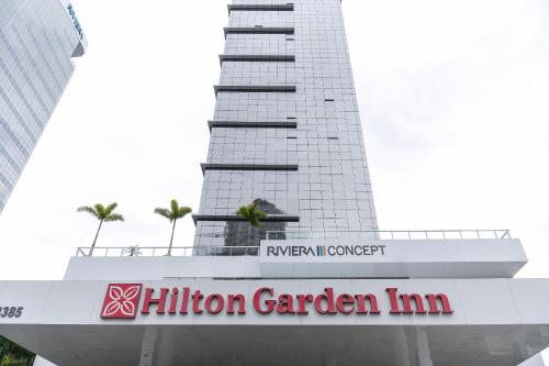 a building with a hilton garden inn sign in front of it at Riviera Concept 2 dorm by Achei Camboriú in Itajaí